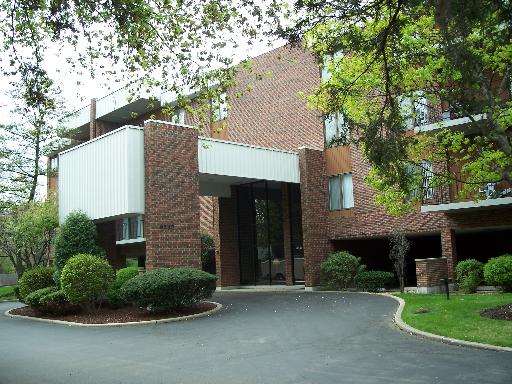 Front view of a multi-story brick building with a covered entrance.