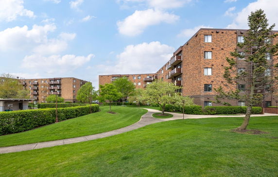 Front view of multi-story apartment buildings with brick exterior.