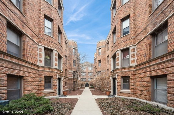 View of brick apartment buildings with a pathway in between.