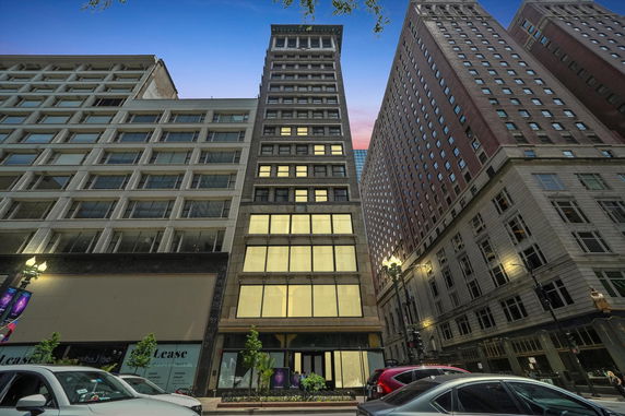 Front view of a multi-story urban building with large windows.