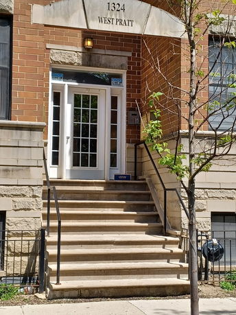 Front view of a building with stairs leading to the main entrance.