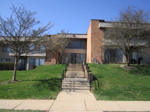 Front view of a multi-story building with a central staircase and brick facade.