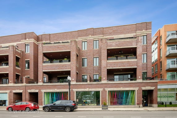 Front view of a multi-story brick building with large windows and balconies.
