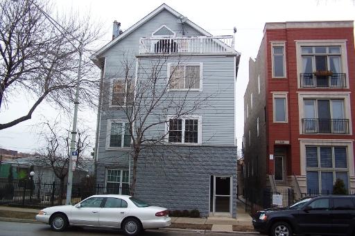 Front view of a multi-story house with a gabled roof and balcony.