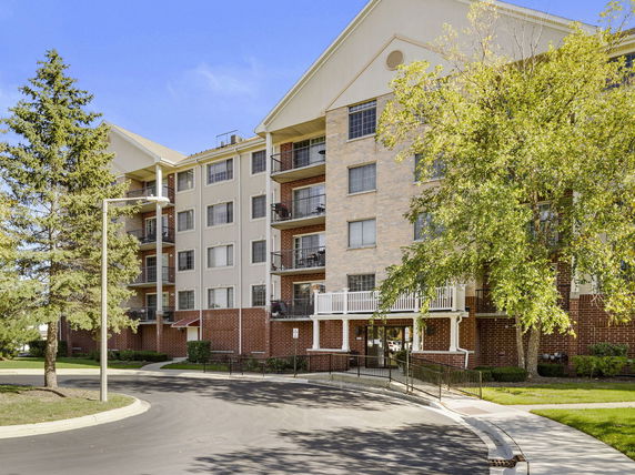 Front view of a multi-story apartment building with balconies.