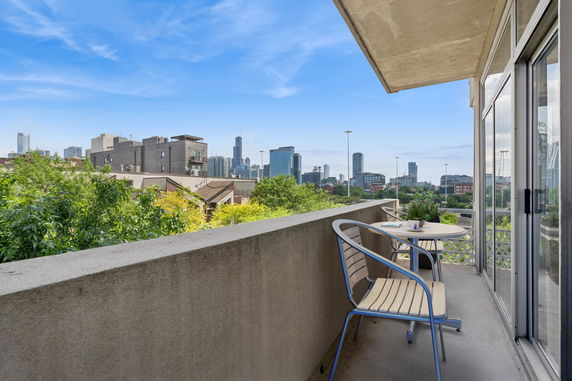Balcony view of city skyline with outdoor seating.