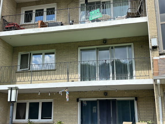 Front view of a multi-story apartment building with balconies.