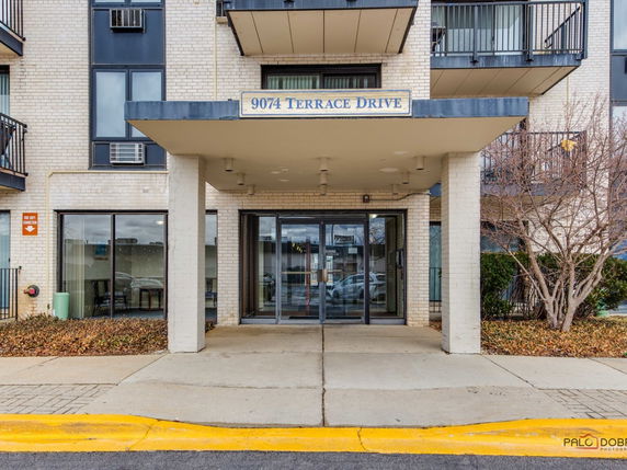 Front view of a building with an entrance canopy and balconies.