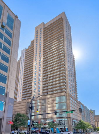 Front view of a tall high-rise building with multiple balconies.