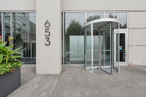 Front view of a building with a revolving glass door and visible building number 653.