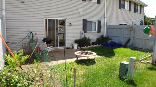 View of the backyard area of a house with a patio and garden.