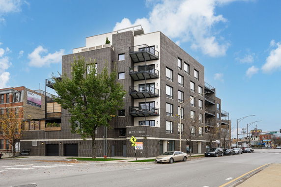 Front view of a multi-story apartment building with balconies.