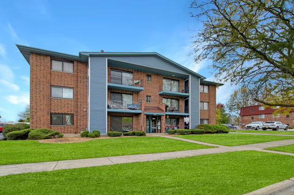 Front view of a mid-rise apartment building with balconies.