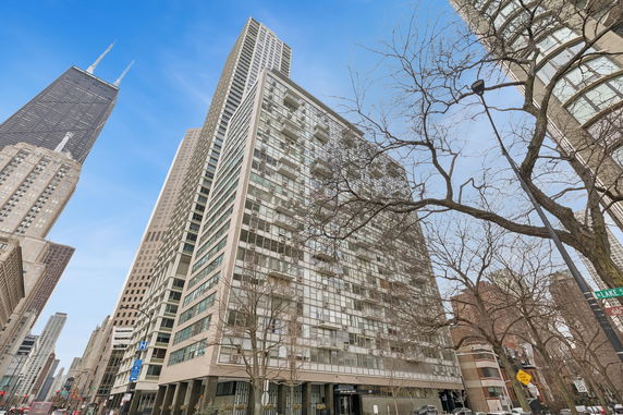 Front view of a multi-story building with glass windows and balconies.