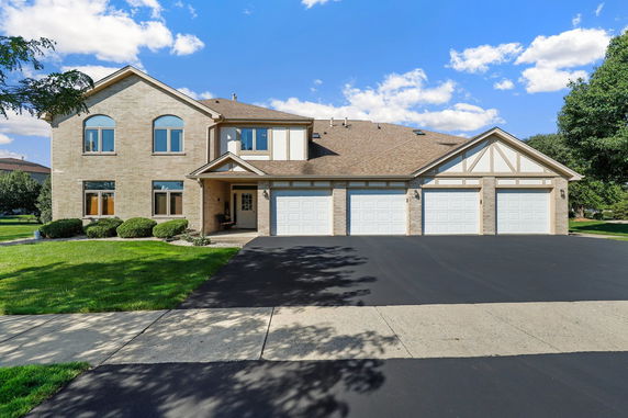 Front view of a large two-story house with a three-car garage.