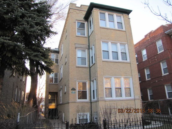 Front view of a multi-story brick apartment building.