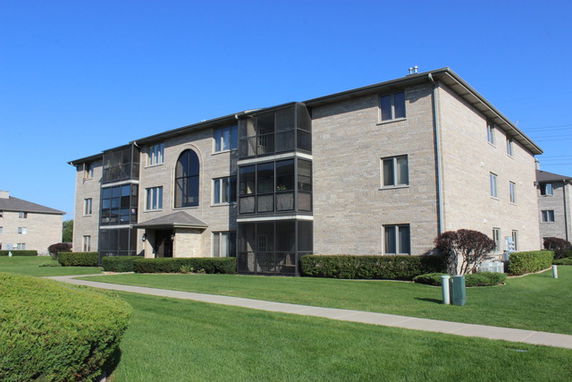 Front view of a multi-story apartment building with brick facade.