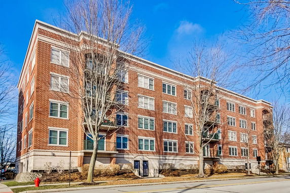 Front view of a four-story brick building with multiple windows.