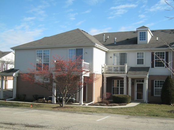 Front view of a two-story house with a balcony.