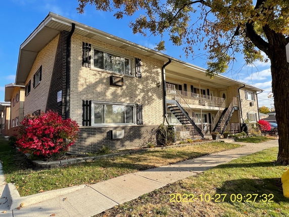 Front view of a two-story apartment building with exterior staircases.
