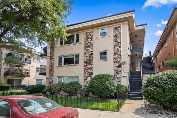 Front view of a two-story apartment building with exterior stairs.