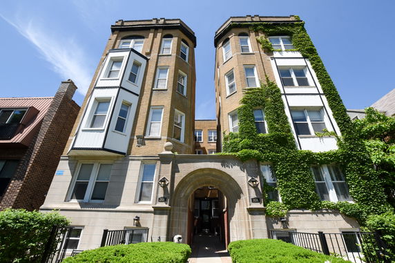 Front view of a multi-story building with ivy-covered walls and bay windows.
