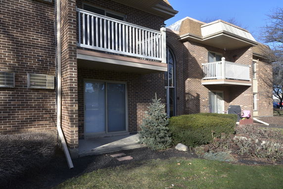 Front view of a brick apartment building with balconies.