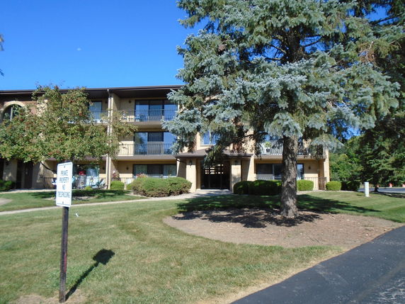 Front view of a multi-story residential building with balconies.