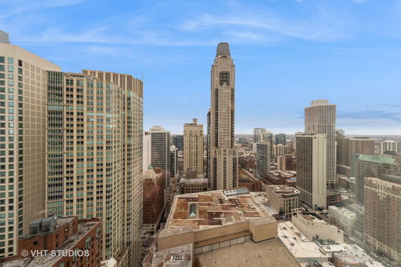 Panoramic view of a city with multiple high-rise buildings under a blue sky.