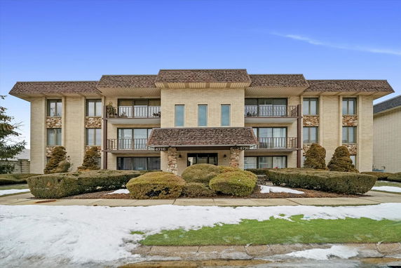 Front view of a multi-story building with symmetrical design and balconies.