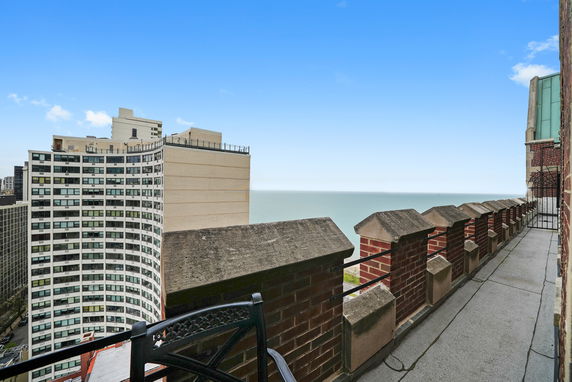 View from a building balcony overlooking another building and the ocean.