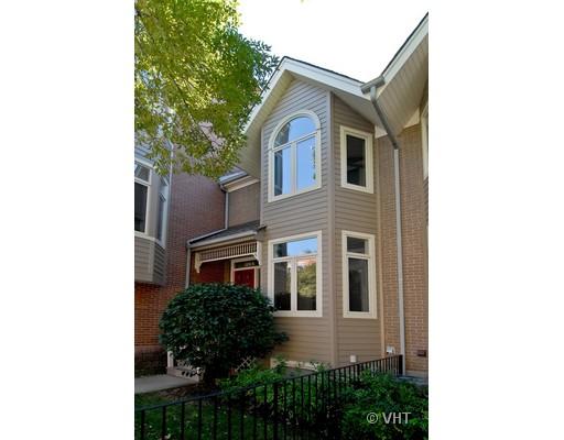Front view of a townhouse with arched windows and beige siding.