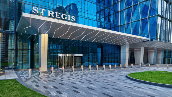 Front view of a modern building entrance with glass facade and a large canopy.