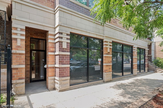 Front view of a brick building with large windows and a glass door.