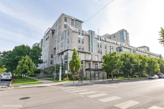 Front view of a multi-story building with balconies and large windows.