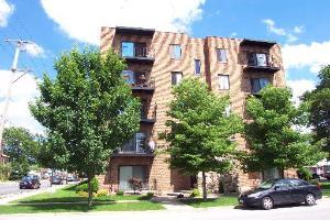 Front view of a multi-story apartment building with balconies.