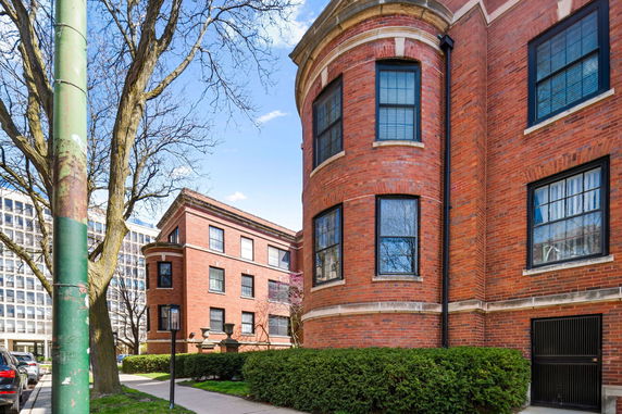 Front view of a multi-story brick building with large windows.