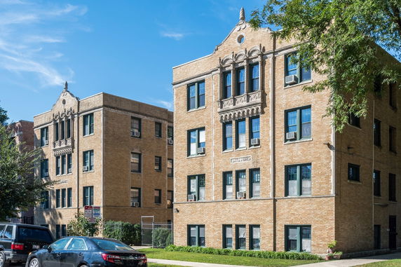Front view of a multi-story brick apartment building with decorative architectural details.