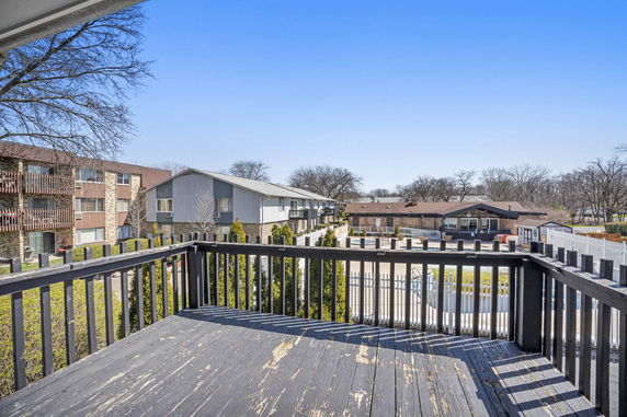 View from a balcony overlooking multiple residential buildings and trees.