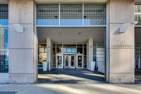 Front view of a building entrance with glass doors and modern design elements.