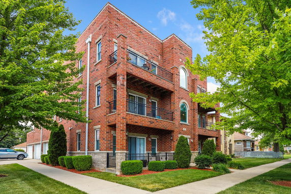 Front view of a multi-story brick building with balconies.