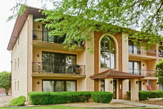 Front view of a multi-story residential building with balconies.