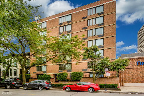 Front view of a multi-story brick building with large windows.