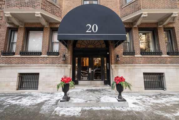 Front view of a building entrance with an awning displaying the number 20.