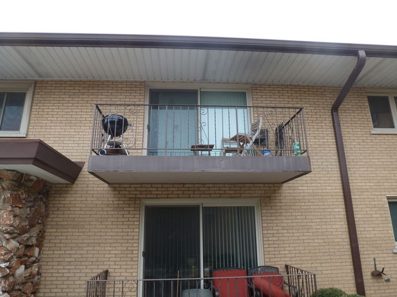 Front view of a brick building with a balcony.