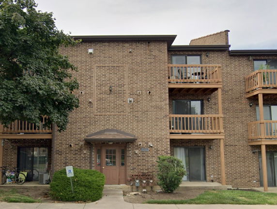 Front view of a brick residential building with balconies.