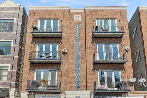 Front view of a multi-story brick building with balconies.