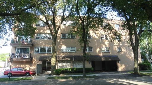 Front view of a multi-story apartment building with balconies.