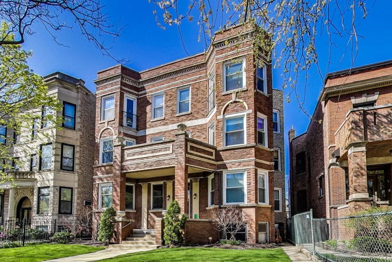 Front view of a three-story brick building with decorative architectural elements.