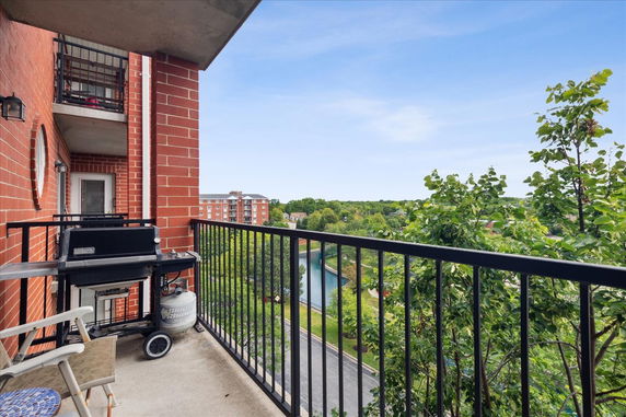 Balcony with a view of distant buildings and greenery.